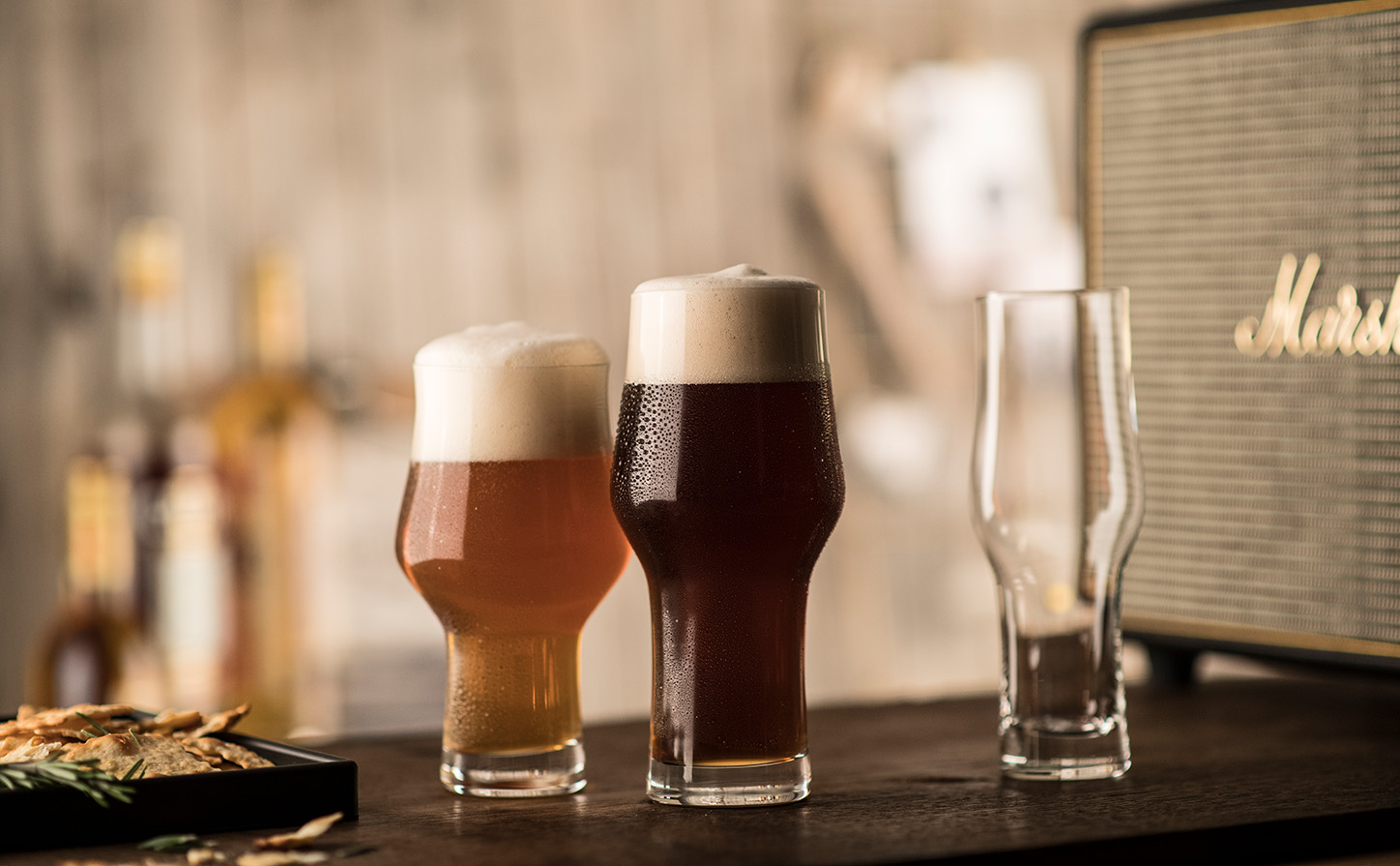 Schott Zwiesel Beer Basic Craft stout glass filled with dark stout beer and a creamy foamy head on a bar counter.