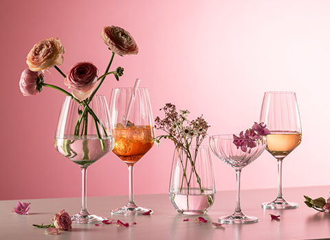 Strukturierte Blossom Gläser mit Blumen und Drinks vor rosafarbenem Hintergrund.