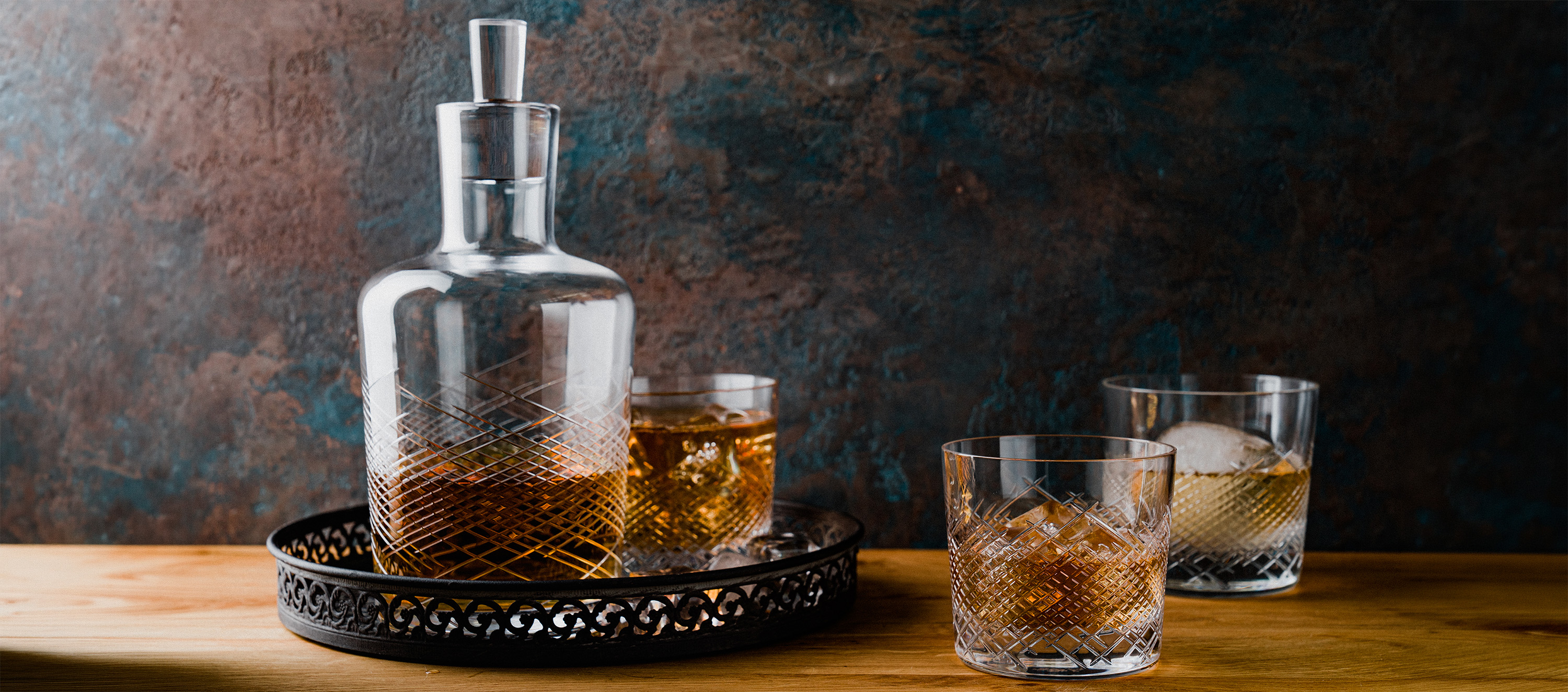 Whiskygläser befüllt mit Eis und Whisky daneben stehend eine Karaffe der selben Serie