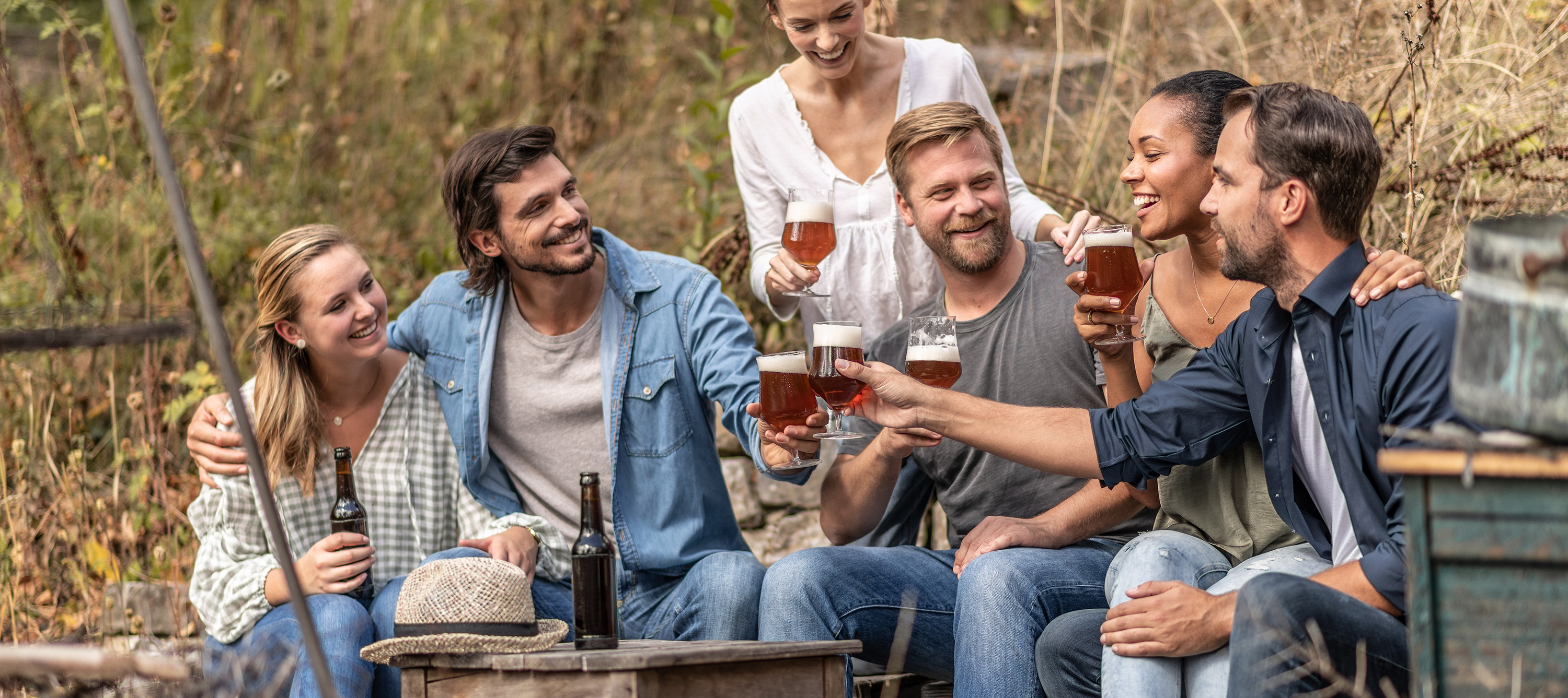 Group of friends toasting outdoors with Schott Zwiesel beer glasses during a relaxed social gathering.
