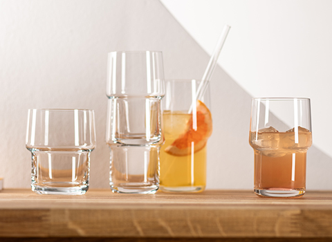 Stackable Click glass tumblers filled with orange drink. Various sizes.
