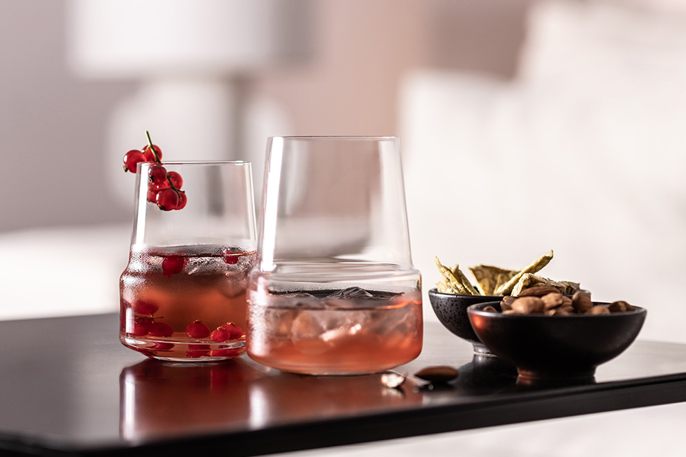 Tumblers from the Level range filled with a red cocktail on a black table.