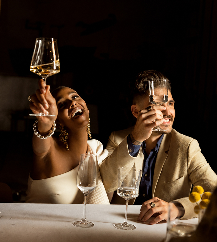 Un couple de mariés faisant la fête et trinquant avec des verres à vin et à champagne