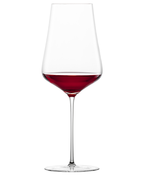 Verre à Bordeaux Duo de Zwiesel Glas, rempli de vin rouge, sur fond blanc.