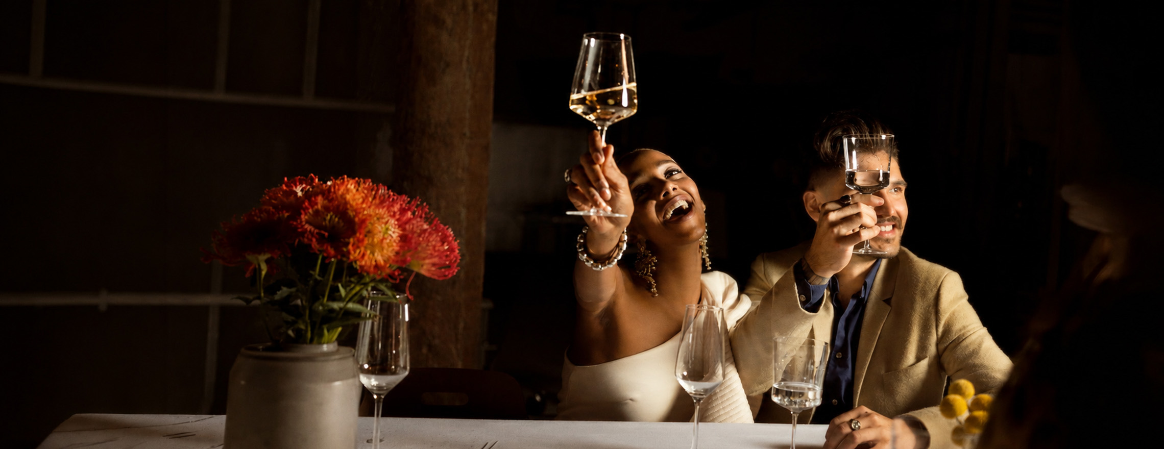 Un couple de mariés faisant la fête et trinquant avec des verres à vin et à champagne