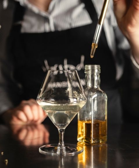 Preparation of a drink with precise dosing using a dropper.