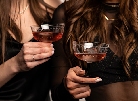 Deux femmes trinquant avec des coupes à cocktail de la série Glamorous